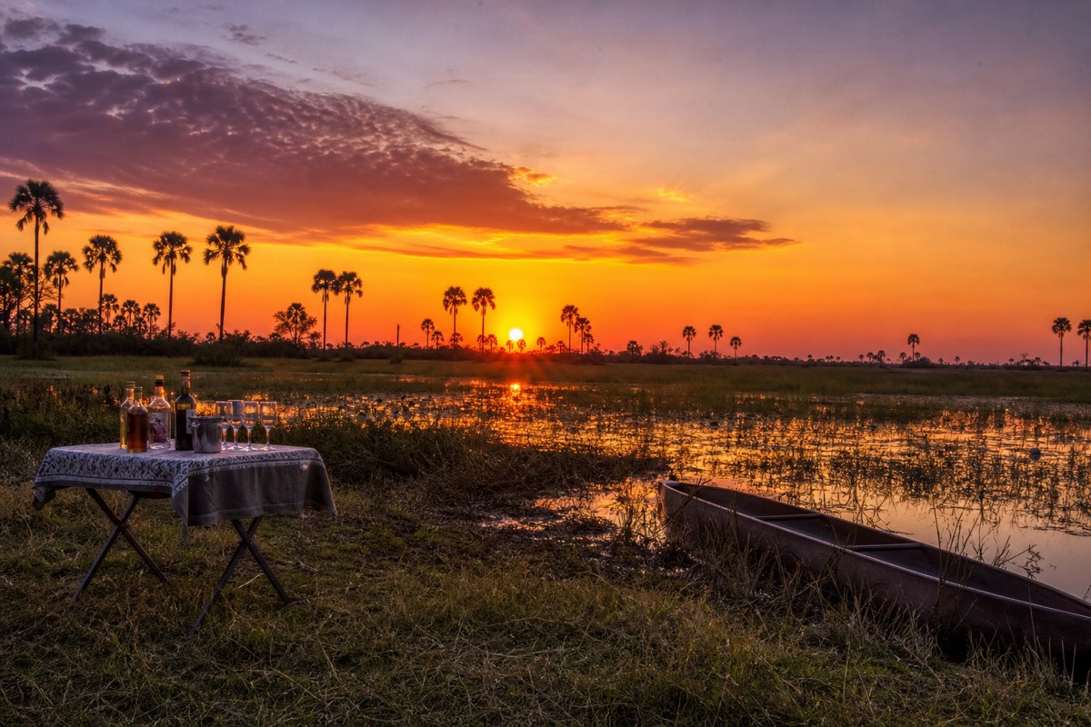 Sundowner drinks set out on a dry island in the Okavango Delta at golden hour